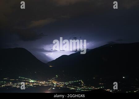 Ein Blitz schlägt über die Berge von meran Stockfoto