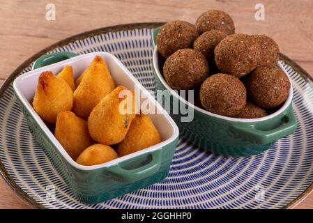 Mischung aus gebratenem herzhaften Snack mit Coxinha, Kebab und gerösteten und gesalzenen Erdnüssen. Stockfoto