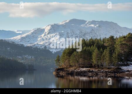 Loch Benevean und die umliegenden schneebedeckten Hügel an einem kalten Morgen im Winter. Glen Affric, Highland, Schottland Stockfoto