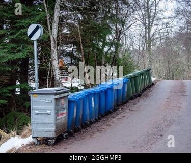 Eine Reihe von gewerblichen Abfällen, blauen Recycling- und grünen Abfallbehältern am Ende einer schmalen Gasse in Highland, Schottland Stockfoto