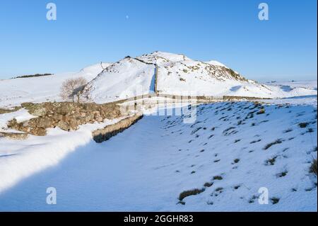 Nordengland, die Landschaft des Northumberland-Nationalparks, die Hadrian's Wall im Winterschnee an einem hellen, sonnigen Tag mit klarem blauem Himmel Stockfoto