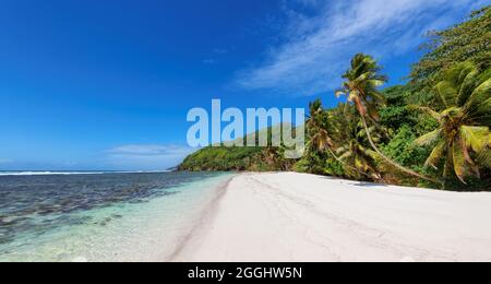Wunderschöner breiter Sandstrand auf einer tropischen Insel im Ozean Stockfoto
