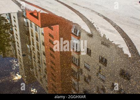 Spiegelung eines Wohnblocks in einem Teich, nach heftigem Regen in Bukarest, Rumänien. Stockfoto