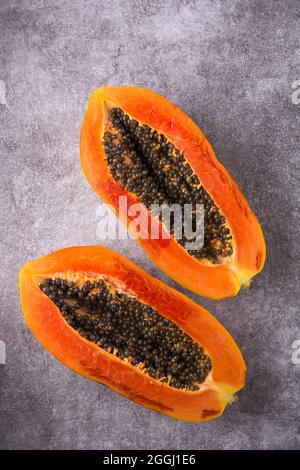 Frische, süße Papaya oder Papaw, bunte Fruchtscheiben isoliert auf einem strukturierten Hintergrund, von oben aufgenommen Stockfoto