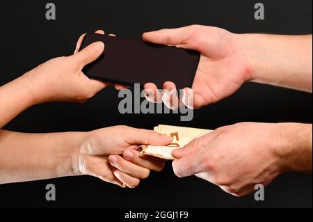 Ein Beispiel für den Einzelhandel mit Smartphones, die Zahlung von Waren in bar, das Empfangen von Geld für verkaufte Waren. Neu Stockfoto