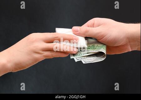 Addict kauft eine Dosis Drogen, weißes Pulver in einem Beutel auf schwarzem Hintergrund. Neu Stockfoto