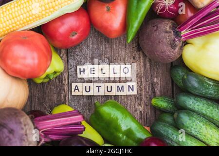 Die Inschrift Hello Autumn auf dem Hintergrund von frischem Bauerngemüse. Herbststimmung und Herbstfutter, Gemüse und Stockfoto