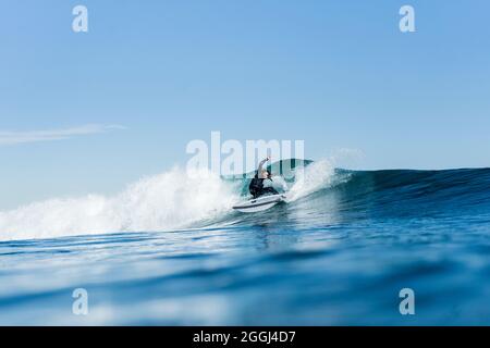 Mann surft und macht ein Surfmanöver auf einer Welle im Meer Stockfoto