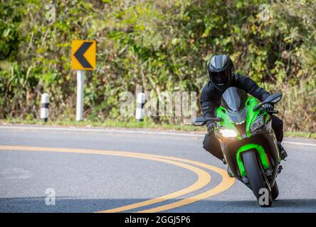 Mann auf seinem Motorrad in den Hügeln des nördlichen Thailand Stockfoto