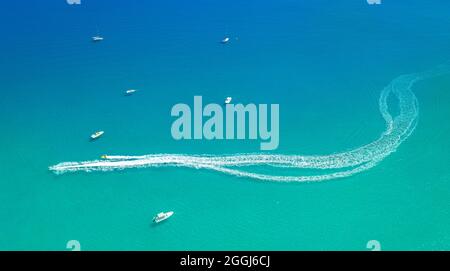 Schnellboote verlassen den Spritzweg auf dem Meerwasser. Wassersport am Meer Luftaufnahme minimalen Hintergrund Stockfoto
