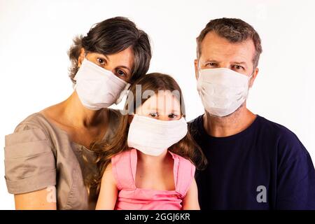 Vater, Mutter und Tochter tragen Schutzmasken auf weißem Hintergrund. Stockfoto