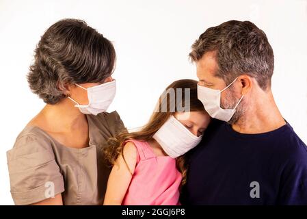 Vater, Mutter und Tochter tragen Schutzmasken auf weißem Hintergrund. Stockfoto