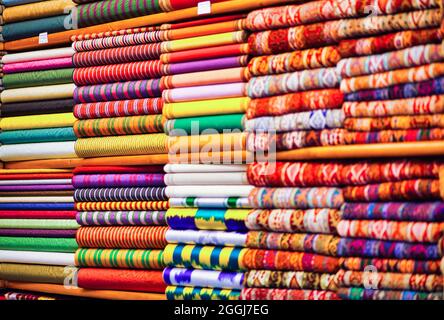 Aufnahme der vielen Textilien mit unterschiedlichen Ornamenten und Texturen übereinander im Shop. Stockfoto