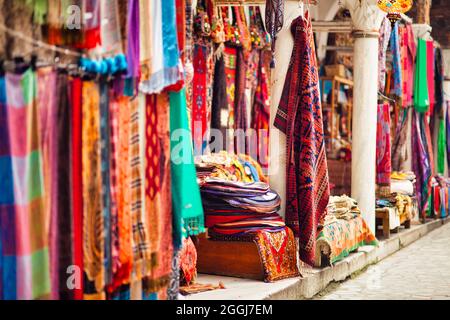 Aufnahme der vielen Textilien mit verschiedenen Ornamenten und Texturen, die auf dem Markt hängen. Stockfoto