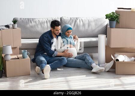 Liebende muslimische Familie wartet auf Baby, Umzug in ein neues Haus Stockfoto