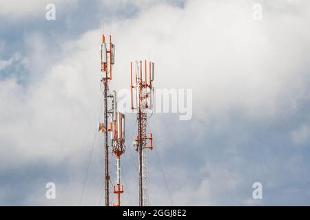 Telekommunikationstürme von mobilen und zellulären Kommunikationsantennen auf dem Hintergrund des Himmels. Stockfoto