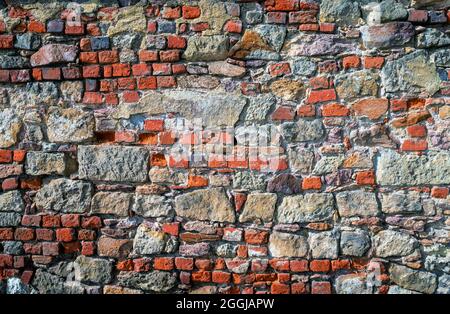 Vintage-Fassade mit Mauerwerk aus roten Ziegeln und Natursteinen Stockfoto