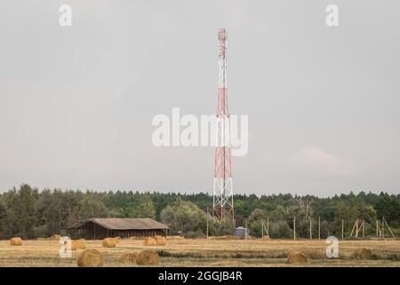 Bewegliche Zelle Turm vor dem Hintergrund eines grauen Himmels in einem offenen Feld der ländlichen Gebiete. Stockfoto