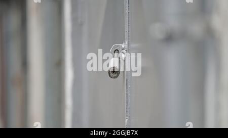 Nahaufnahme einer kleinen Metallverriegelung auf einer grauen Industrietafel mit geringer Schärfentiefe. Stockfoto