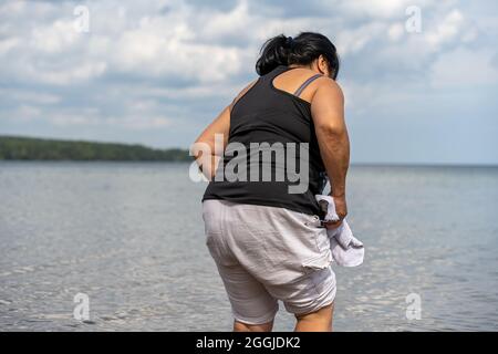 Eine asiatische Frau mittleren Alters an einem See Stockfoto