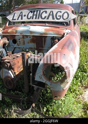 Ein alter verrostet-out Oldtimer bedeckt mit Überwuchserde mit einem Schild mit der Aufschrift LA - Chicago Stockfoto