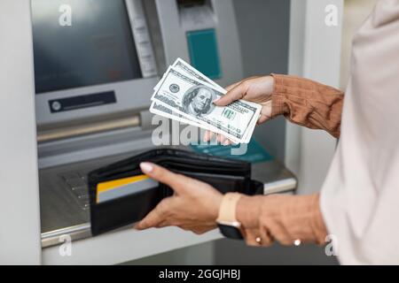 Junge Frau von der Kreditkarte Geld abheben am Geldautomat Stockfoto