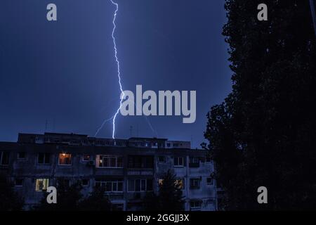 An einem stürmischen Abend entfacht der Himmel Blitze über der Stadt Bukarest. Stockfoto