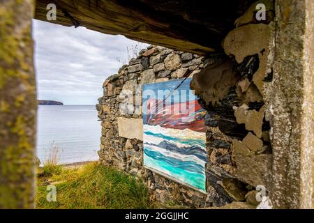 Ein altes, ruiniertes und dachloses Gebäude mit alten Booten bildet eine ungewöhnliche Kunstgalerie in der Skerray Bay an der Nordküste Schottlands direkt vor der NC500. Stockfoto