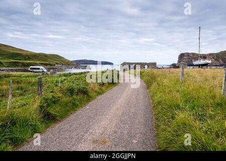 Eine einspurige Strecke führt zur Skerray Bay, direkt an der NC500, an der Nordküste Schottlands. Am Horizont steht Eilean Nan Ron. Stockfoto