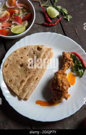 Einfache nordindische Mahlzeit Paratha oder Fladenbrot mit würzigem Huhn serviert. Draufsicht. Stockfoto