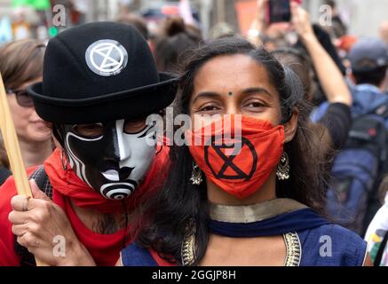 Junge asiatische Frau bei einem Protest gegen die Auslöschung der Rebellion vor der Bank of England, London, Großbritannien. August 2021. Tragen einer XR-Gesichtsmaske Stockfoto