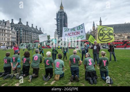 London, Großbritannien. September 2021. Die Menschen erklären HEUCHELEI vor der GREENWASH-Wahing-Linie und dem Parlament. Extinction Rebellion trifft sich auf dem Parliament Square, um der britischen Regierung Greenwaishing vorzuwerfen. Vor der COP26 behauptet sie, dass wir eine Nation mit sauberer Energie sein werden, aber weiterhin Öl und Gas ausgeben, das für die Nordsee zugelassen ist, weigert sich, das neue riesige Öl- und Gasfeld von Cambo zu blockieren und investiert 750 Millionen £in ein Gasexportterminal in Mosambik. Peter Marshall/Alamy Live News Stockfoto