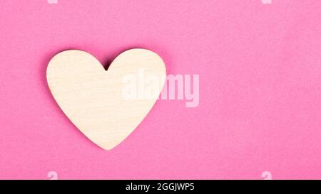 valentine Holzherz auf rosa Hintergrund mit Kopierraum. Stockfoto