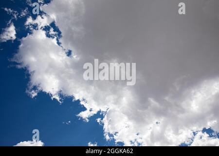 Flauschige weiße Wolken und ein tiefblauer Himmel. Stockfoto