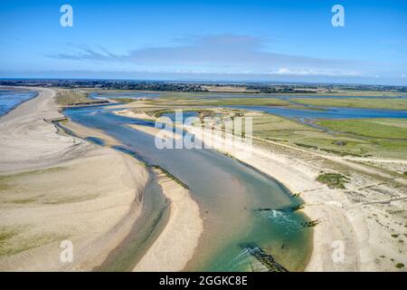 Der Hafen von Pagham spuckt beim Luftbild bei Ebbe den Eingang mit dem Naturschutzgebiet in diesem Paradies für Wildtiere aus. Stockfoto