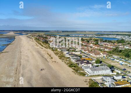 Luftbild am Strand von Pagham in West Sussex, mit der Pagham Lagoon und dem Holiday Park neben dem Naturschutzgebiet. Stockfoto