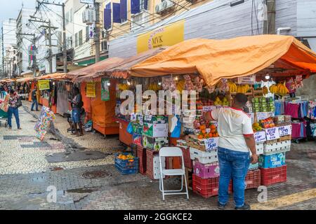 Private Kleingeschäftskiosks im Marktviertel an einer engen Kopfsteinpflasterstraße in Niteroi, Rio de Janeiro, Brasilien. Beiläufige Personen sind in zu sehen Stockfoto