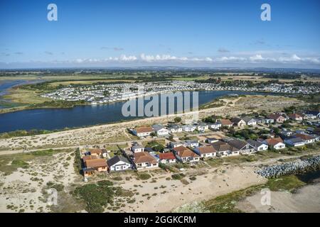 Pagham Lagoon in West Sussex in der Nähe des Hafens und der Küste mit Ferienhäusern am Ufer dieses Ferienortes in England. Stockfoto