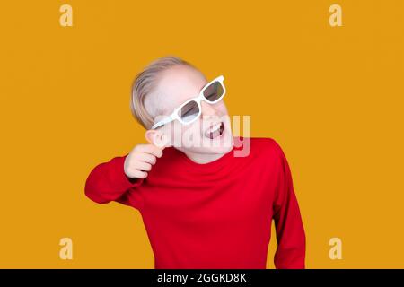 Lustige Kind in Brille 3d-Film zieht sich am Ohr Stockfoto