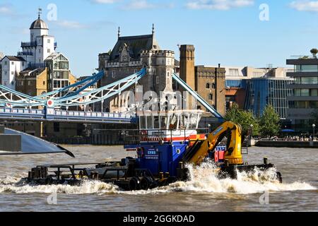 London, England - August 2021: Industriekahn mit Baggerausrüstung auf der Themse Stockfoto