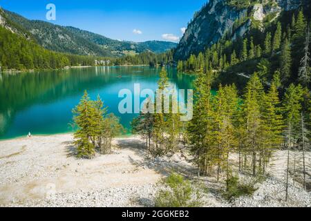 Luftaufnahme auf dem Pragser Wildsee, einem See in den Südtiroler Dolomiten. Hohe Gebirgsketten um den See herum. Der Himmel und die Berge spiegeln sich im See. Stockfoto