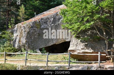 Große Felsenhöhle am Eingang zur Schwarzen Lagune. Gepflasterte Straße mit Holzgeländer, Provinz Soria, Spanien. Stockfoto