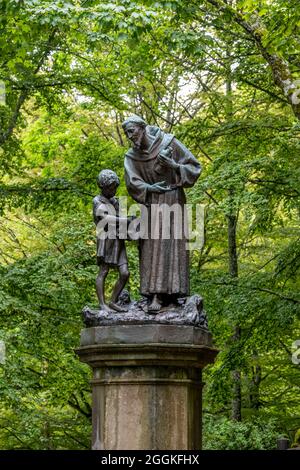 Bronzestatue des heiligen Franziskus mit Kind in La Verna, Franziskanerschutzgebiet, Chiusi della Verna, Arezzo, Toskana, Italien Stockfoto