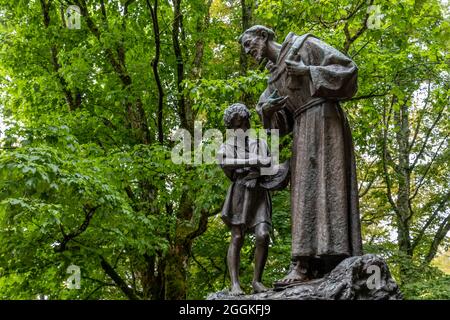 Bronzestatue des heiligen Franziskus mit Kind in La Verna, Franziskanerschutzgebiet, Chiusi della Verna, Arezzo, Toskana, Italien Stockfoto