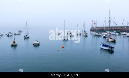 Neblige Stimmung im Hafen von Erquy, im Hintergrund der kleine Leuchtturm am Pier, Frankreich, Bretagne, Département Côtes d´Armor, Côte de Penthièvre Stockfoto