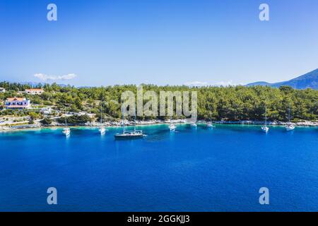 Luftbild von Segelbooten, die in der blauen Bucht von Fiskardo, Insel Kefalonia, Ionisches, Griechenland angedockt sind Stockfoto