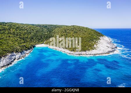 Luftaufnahme des abgelegenen Dafnoudi-Strandes in Kefalonia, Griechenland, abgeschiedene Bucht mit reinem kristallklarem türkisfarbenem Meerwasser, umgeben von Zypressen. Stockfoto