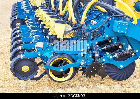Blaue moderne mehrreihige Pflanzmaschine, Räder, Verteilrohre und Arbeitsmechanismen der pneumatischen landwirtschaftlichen Sämaschine. Speicherplatz kopieren. Stockfoto