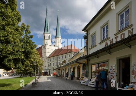 Deutschland, Bayern, Altötting, Kapellplatz mit der Stiftskirche St. Philip und James und Devotionalgeschäften Stockfoto