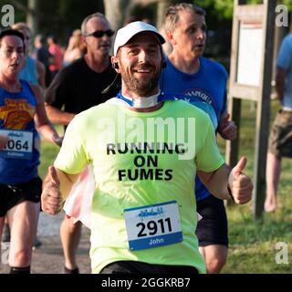 North Babylon, New York, USA - 8. Juli 2019: Mann gibt zwei Thrum in einem Hemd, das liest laufen auf Dämpfen beim Laufen in einem Rennen 5K. Stockfoto